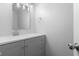 Bathroom featuring gray vanity with quartz counters, modern fixtures, and stylish mirror at 1127 Junco Dr, Columbus, IN 47203