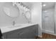 Bathroom showcasing dual sinks with modern fixtures and a tiled shower at 1127 Junco Dr, Columbus, IN 47203
