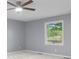 A calming bedroom features a ceiling fan and a window view of lush greenery at 1127 Junco Dr, Columbus, IN 47203