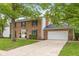 Charming two-story brick home featuring a well-manicured lawn, mature trees, and a spacious driveway at 1127 Junco Dr, Columbus, IN 47203