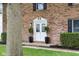 The facade of the brick home featuring a white double-door entry with black accents and green lawn at 1127 Junco Dr, Columbus, IN 47203