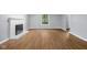 Living room with wood-look flooring, neutral walls, a window, and a fireplace at 1127 Junco Dr, Columbus, IN 47203