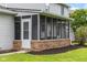 Exterior view of a charming screened-in porch with brick accents and convenient door access at 1127 Junco Dr, Columbus, IN 47203