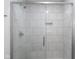 Shower featuring a glass door and white tiled walls with a built-in niche at 1127 Junco Dr, Columbus, IN 47203