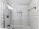 Modern bathtub with shower features white subway tile surround and glass door at 1201 Villa Ave, Indianapolis, IN 46203
