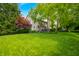 Spacious backyard featuring lush green grass, mature trees, and a deck for outdoor entertaining at 1245 Elm Grove Ln, Greenwood, IN 46143