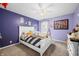 Bedroom featuring stylish decor, ceiling fan, white bed frame, and purple accent wall at 1245 Elm Grove Ln, Greenwood, IN 46143