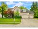 Charming two-story brick home with a well-manicured lawn and mature trees on a sunny day at 1245 Elm Grove Ln, Greenwood, IN 46143