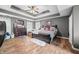 Main bedroom with wood floors, ceiling fan, tray ceiling, and dark wood dresser at 1245 Elm Grove Ln, Greenwood, IN 46143