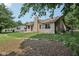 The home's backyard features a grassy area, mature trees, and a brick border at 1311 Old Hickory Dr, Greenwood, IN 46142