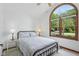 Cozy bedroom with large arched window, white walls, neutral carpet, and space for a full sized bed at 1311 Old Hickory Dr, Greenwood, IN 46142