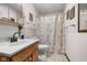 Cozy bathroom featuring classic fixtures, a wood vanity, and floral shower curtain, offering a functional design at 1350 Inverness Farms Rd, Martinsville, IN 46151