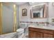 Bathroom with gold-trimmed shower, tile surround, neutral vanity, medicine cabinet, toilet and a view to shelving at 1350 Inverness Farms Rd, Martinsville, IN 46151