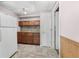 Basement kitchenette features wood cabinets, a mosaic tile backsplash, neutral countertops, and a full-size refrigerator at 1350 Inverness Farms Rd, Martinsville, IN 46151