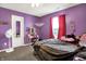 A bright purple bedroom with decor, a dressing table, and natural light from the window at 1375 Crabapple Rd, Franklin, IN 46131