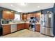 Charming kitchen with stainless steel appliances, wood cabinetry, and neutral tiled backsplash at 1375 Crabapple Rd, Franklin, IN 46131