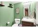 Green powder room featuring a sink, mirror, toilet, and open storage shelves at 1375 Crabapple Rd, Franklin, IN 46131