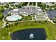 Stunning aerial view of the clubhouse, pool, bocce ball courts, and pond with fountain feature at 15937 Marsala Dr, Fishers, IN 46037