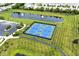 Overhead view of the community's blue and green tennis courts surrounded by lush landscaping and pond at 15937 Marsala Dr, Fishers, IN 46037