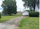 Long driveway leading to a detached garage with ample green space on either side at 1637 Meridian St, Columbus, IN 47201