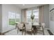 An elegant dining area with a table for six, large windows, and sliding door with a view to the yard at 16465 Mount Logan Rd, Noblesville, IN 46060
