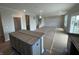 Unfinished open concept living room area with a kitchen island and stairs at 16465 Mount Logan Rd, Noblesville, IN 46060