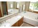 Bathroom featuring double sinks, a large mirror, and a jacuzzi tub at 1739 S County Road 450 E, Avon, IN 46123