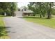 View of the home and surrounding landscaping featuring mature trees, a large driveway and green lawn at 1739 S County Road 450 E, Avon, IN 46123