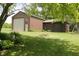 Exterior shot of a garage with a large door, surrounded by greenery and trees at 1739 S County Road 450 E, Avon, IN 46123