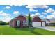 Charming brick home on a green lawn with a two-car garage and blue skies at 217 Saint Andrews Ave, Edinburgh, IN 46124