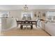 Inviting dining area with wood table, neutral chairs, and bench seating adjacent to a light and airy living space at 2580 Bluewood Way, Plainfield, IN 46168