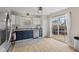 Bright kitchen featuring white upper cabinets, blue lower cabinets, stainless steel appliances, and sliding glass doors to the deck at 2580 Bluewood Way, Plainfield, IN 46168