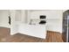 Open kitchen featuring an island with white countertops, stainless steel appliances, and wood-look floors at 2733 Bo W St, Plainfield, IN 46168