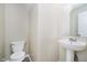 Powder room featuring a pedestal sink, a white toilet, and neutral walls at 2834 Wolfgang Dr, Indianapolis, IN 46239