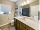 Well-lit bathroom featuring a sink with countertop, toilet, window and mirror, accented by neutral tones for a clean and modern feel at 3150 Green Brook Ln, Frankfort, IN 46041