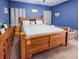 A bedroom with blue walls, hardwood furniture, and plush carpet at 3150 Green Brook Ln, Frankfort, IN 46041