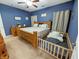 Comfortable bedroom with blue walls, wood furniture, and an adjacent toddler bed at 3150 Green Brook Ln, Frankfort, IN 46041