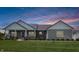Charming single-story home with stone accents, manicured lawn and front porch at sunset at 3150 Green Brook Ln, Frankfort, IN 46041