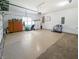 Spacious garage with epoxy flooring, featuring storage cabinets, a refrigerator, and ample room for multiple vehicles at 3150 Green Brook Ln, Frankfort, IN 46041