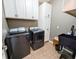Modern laundry room equipped with a washer, a dryer, white cabinets, and a sleek sink for efficient cleaning at 3150 Green Brook Ln, Frankfort, IN 46041