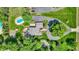 Aerial view displays home with pool, patio, circular drive, mature trees offering privacy and charm at 3528 E 116Th St, Carmel, IN 46033