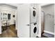 Hallway view of a laundry area with stacked washer and dryer, and view into home office and bathroom at 3528 E 116Th St, Carmel, IN 46033