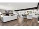 Open concept living room with hardwood floors, a stone fireplace, and a seamless transition to the kitchen at 3528 E 116Th St, Carmel, IN 46033