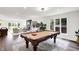 Bright living space with pool table, piano, and large windows overlooking the beautiful backyard at 3528 E 116Th St, Carmel, IN 46033