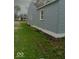 Exterior view of a light blue home featuring a side yard and white foundation at 3626 N Denny St, Indianapolis, IN 46218