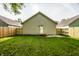 View of the backyard featuring new wooden fence, garage and a well-manicured lawn at 3818 Fetlock Dr, Indianapolis, IN 46227