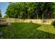 Large grassy backyard featuring a newly constructed wooden fence and lush green trees at 3818 Fetlock Dr, Indianapolis, IN 46227