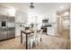 Modern kitchen featuring white cabinets, stainless steel appliances, a dining table, and light wood flooring at 3818 Fetlock Dr, Indianapolis, IN 46227