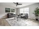 Bright living room featuring neutral walls, modern furniture, large window, ceiling fan, and stylish decor at 3818 Fetlock Dr, Indianapolis, IN 46227