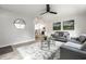 Bright living room featuring neutral walls, modern furniture, large windows, ceiling fan, and stylish decor at 3818 Fetlock Dr, Indianapolis, IN 46227